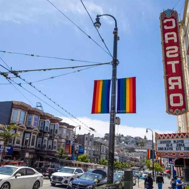 The 卡斯特罗 neighborhood of San Francisco, with the 卡斯特罗 Theater sign and rainbow flags in the foreground.